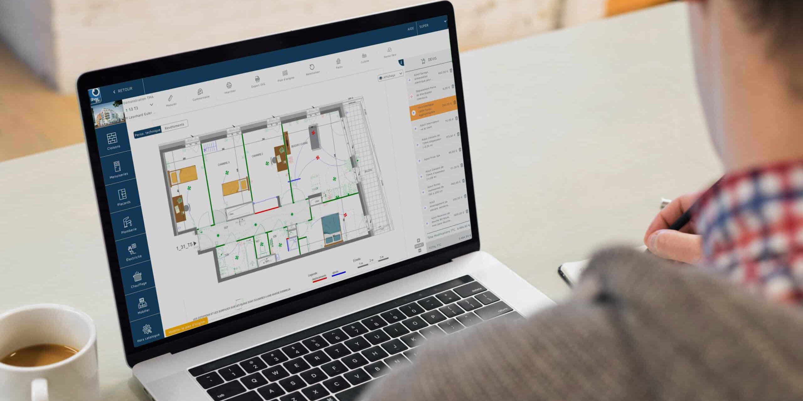 mock-up-écran-V3-TMA Hand partners investit dans show you : un personne assis, devant lui un bureaur blanc sur lequel se trouve un ordinateur portable.ET à gauche une tasse de café blanche