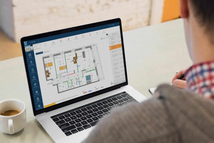 Hand partners investit dans show you : un personne assis, devant lui un bureaur blanc sur lequel se trouve un ordinateur portable.ET à gauche une tasse de café blanche