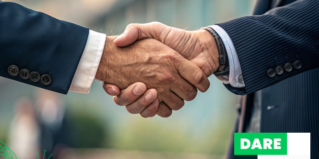 Deux mains vêtues d'un costard se serrent la main. En arrière-plan, un fond flou, et en bas à droite, le logo DARE DONE ( Investissement HAND PARTNERS).